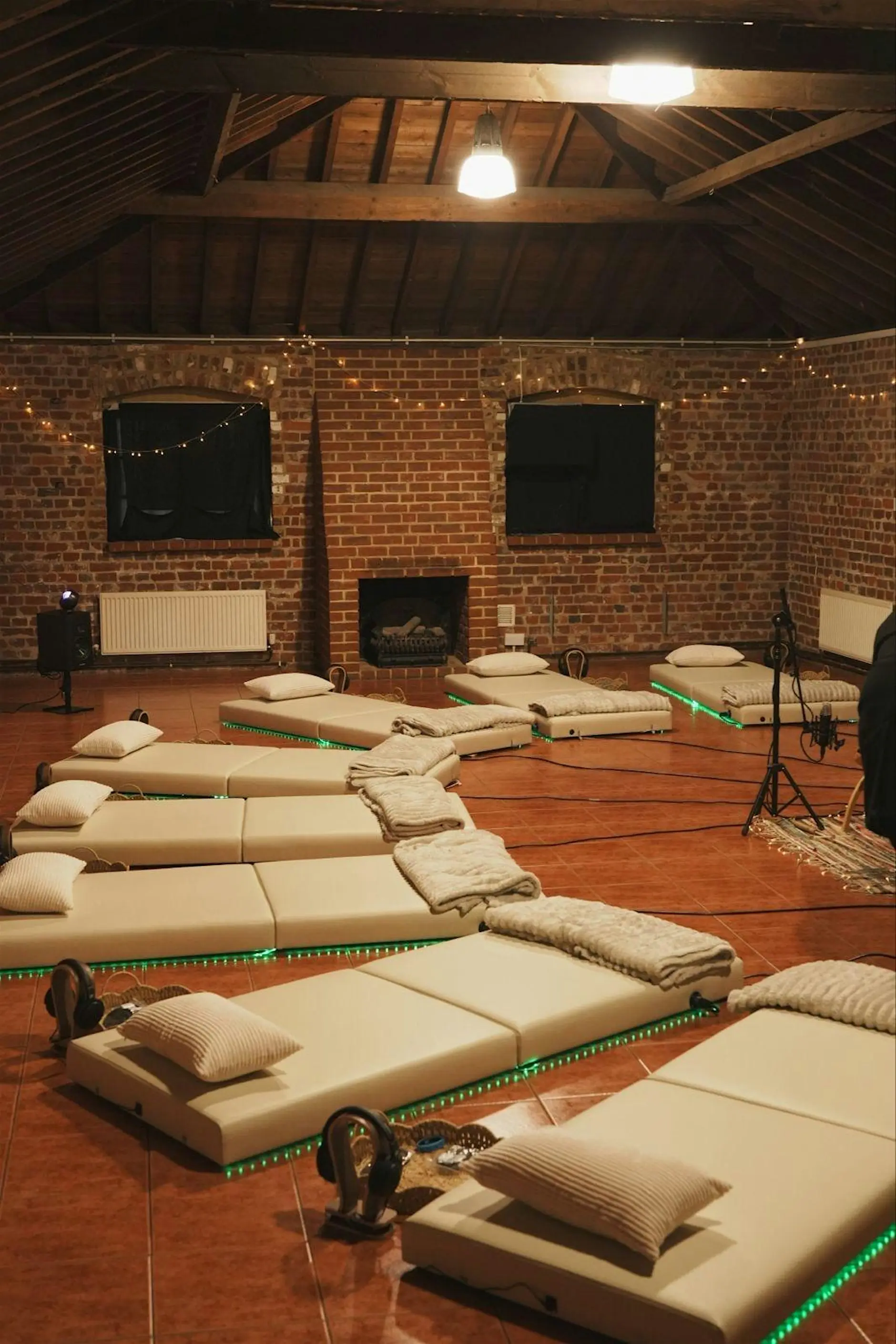 Onizion vibroacoustic beds laid out in a high-ceilinged brick room with microphones and recording equipment in place, ready for a session